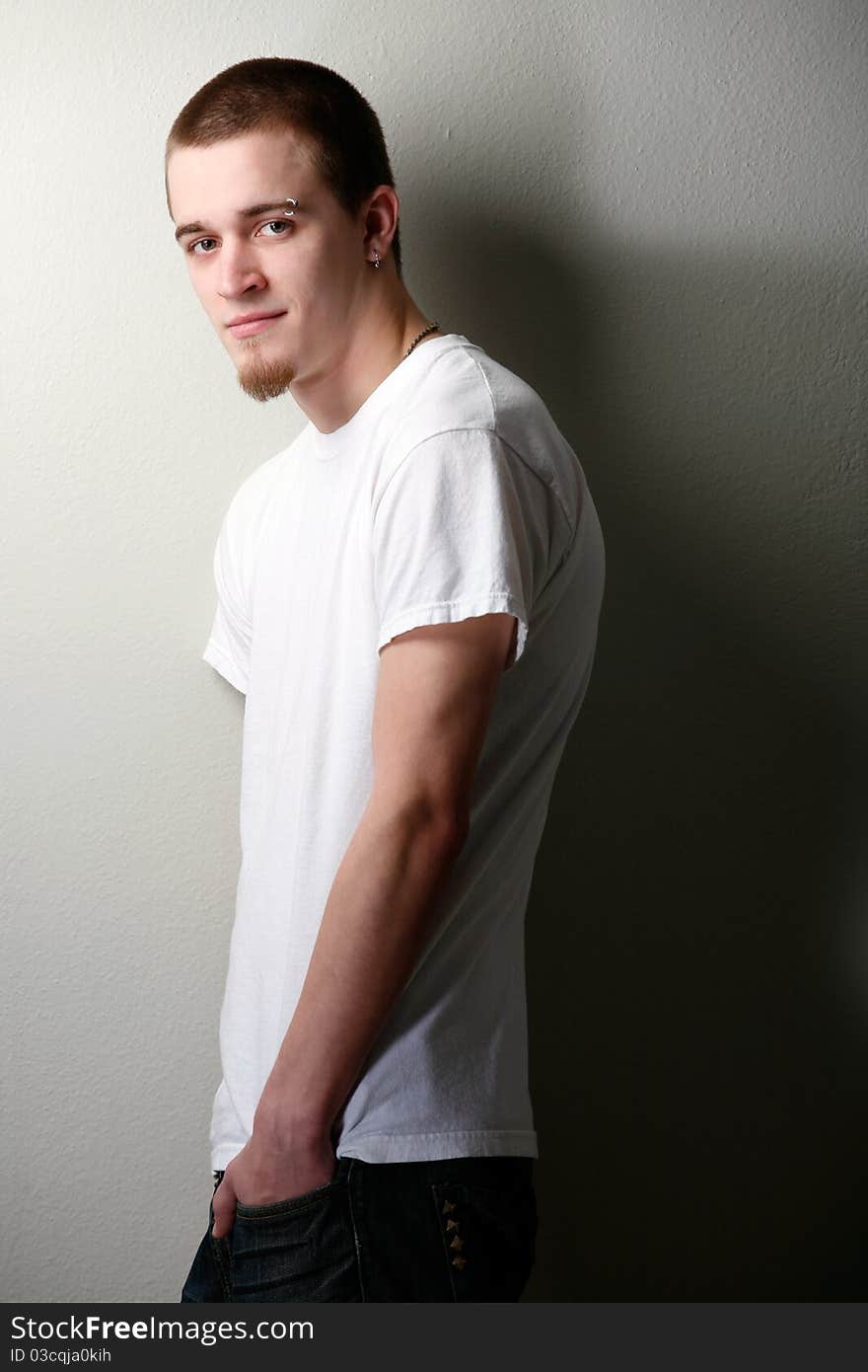 Young man poses wearing t-shirt and jeans. Young man poses wearing t-shirt and jeans.