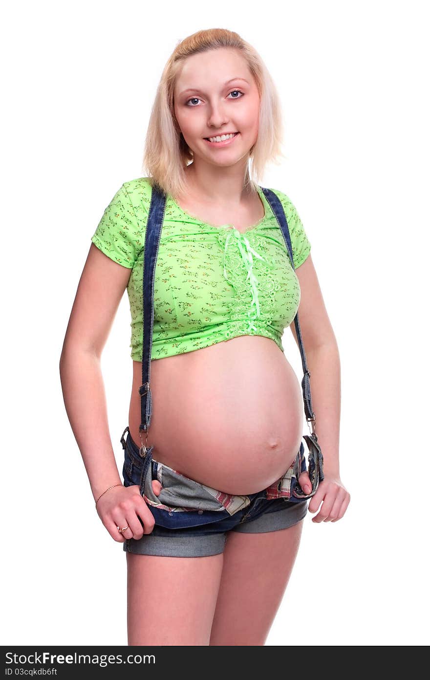 Young pretty pregnant woman posing in jeans overalls