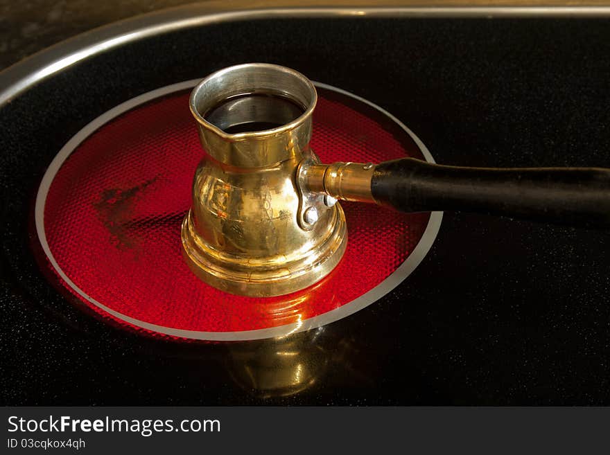 Arab small coffee pot on red hot ceramic stove of electric cooker. Arab small coffee pot on red hot ceramic stove of electric cooker