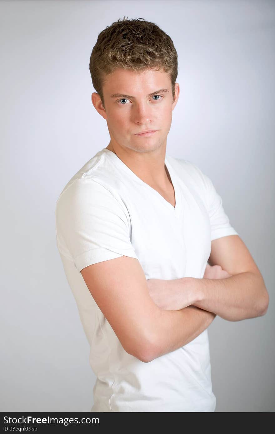 Young man poses with arms folded. Young man poses with arms folded.