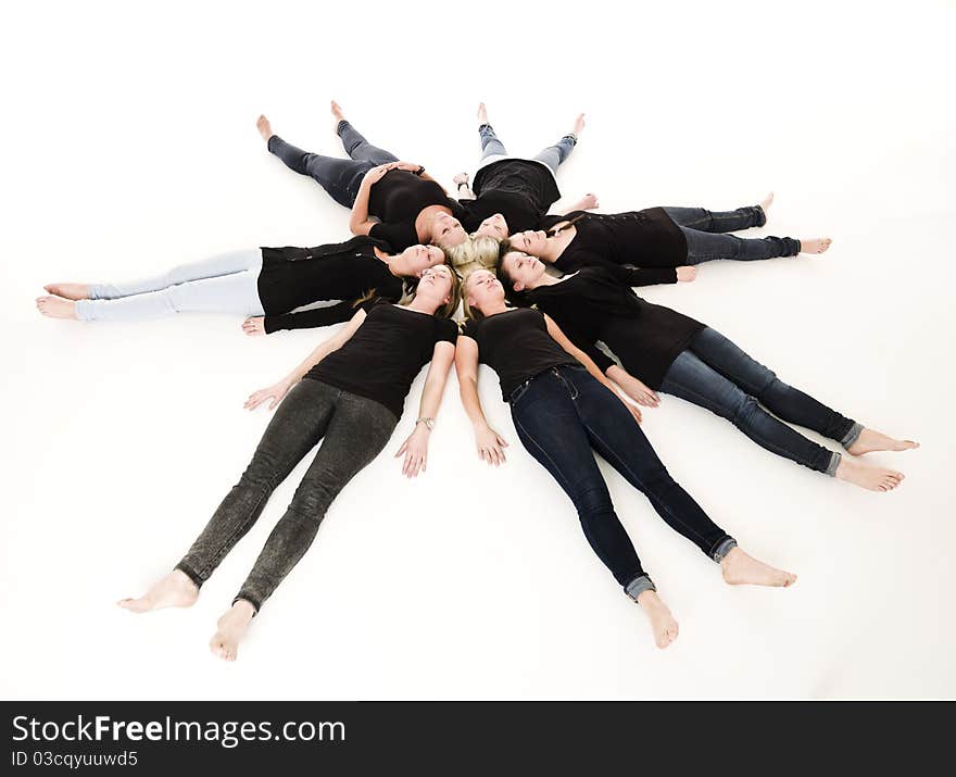 Group of Young Women lieing in a circle on white background