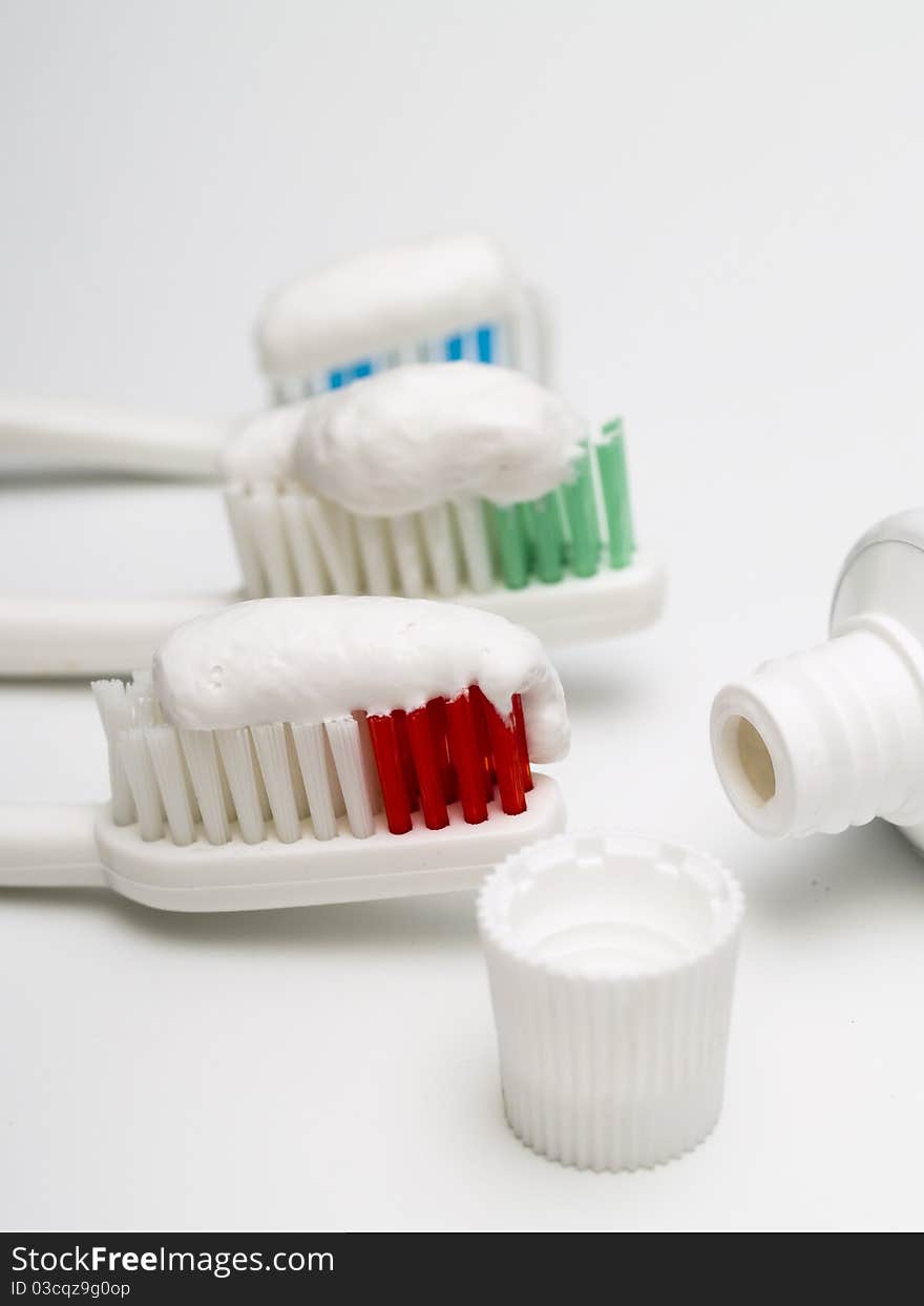 Colorful toothbrushes with toothpaste and a tube