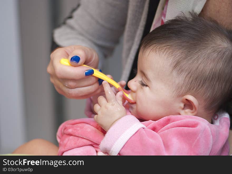 Baby Girl eating with her Mother