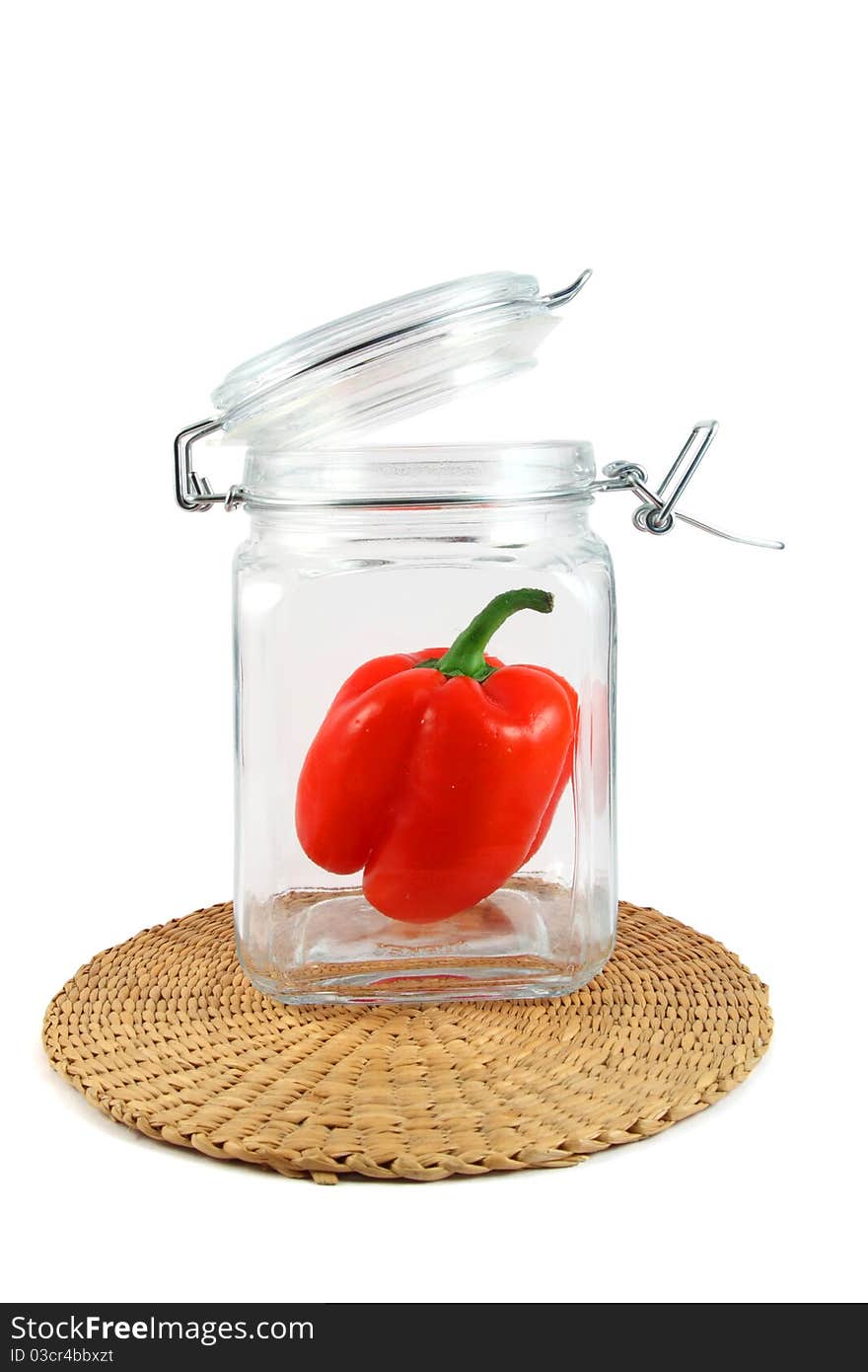 Red pepper in glass jar on white background