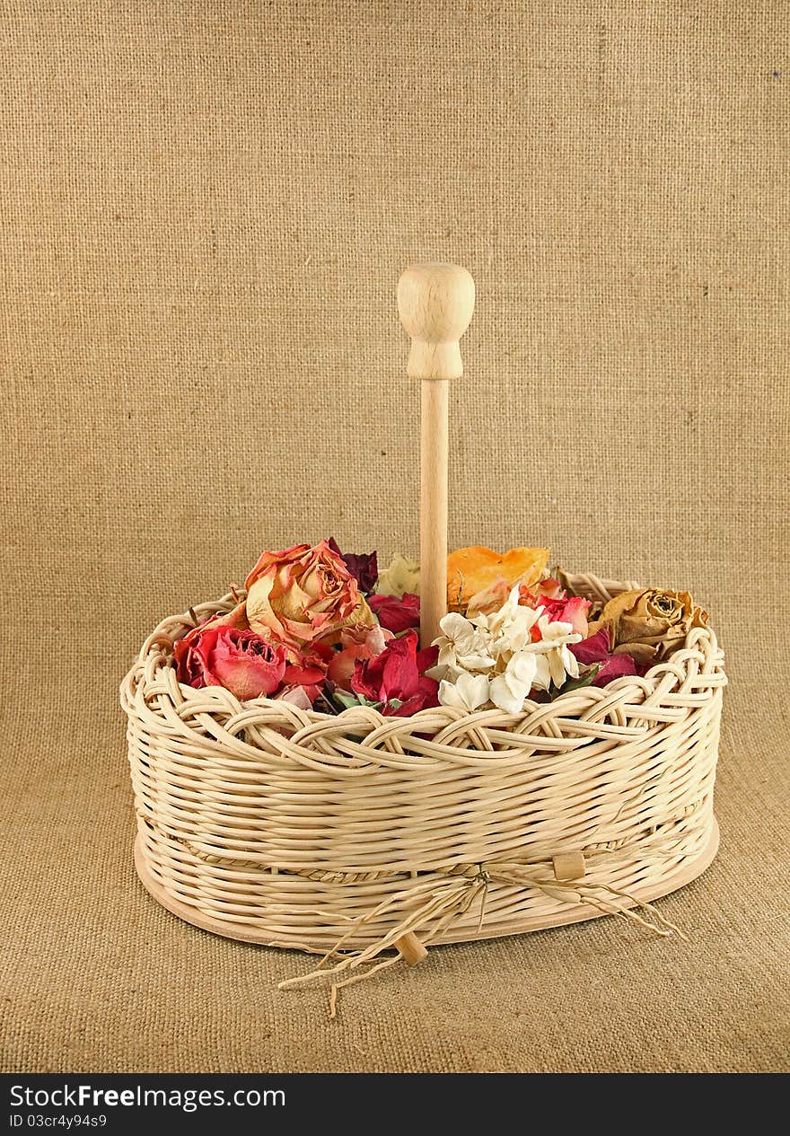 Dry flowers in the basket on jute background