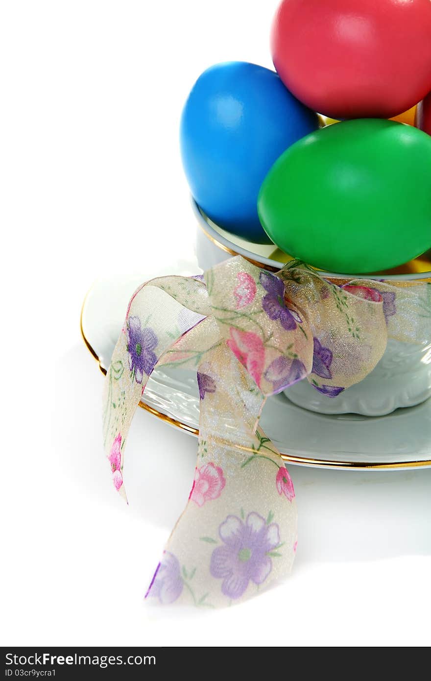 Easter eggs in a teacup on a white background.