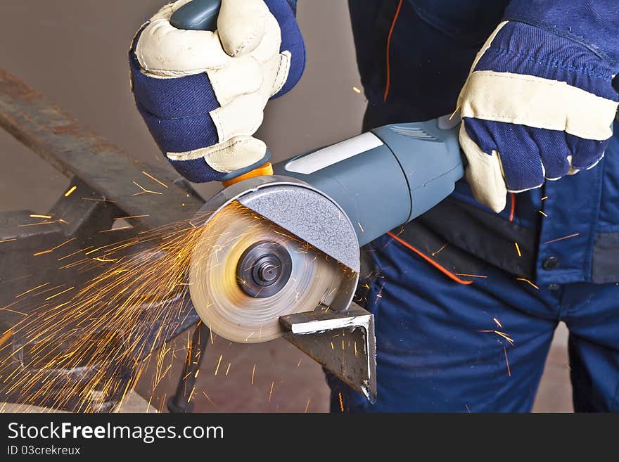 A man working with grinder, close up on tool, hands and sparks, real situation picture. A man working with grinder, close up on tool, hands and sparks, real situation picture