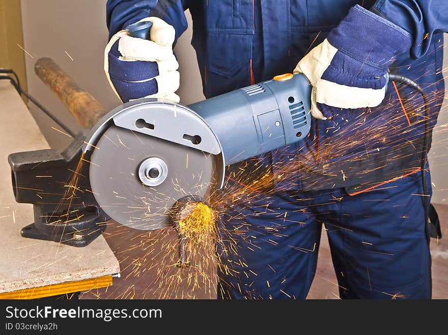 A man working with grinder, close up on tool, hands and sparks, real situation picture. A man working with grinder, close up on tool, hands and sparks, real situation picture