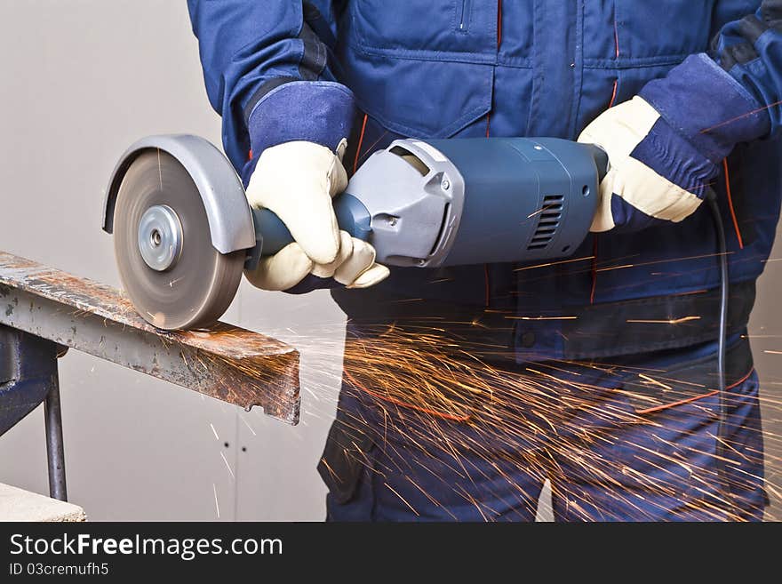 A man working with grinder, close up on tool, hands and sparks, real situation picture. A man working with grinder, close up on tool, hands and sparks, real situation picture