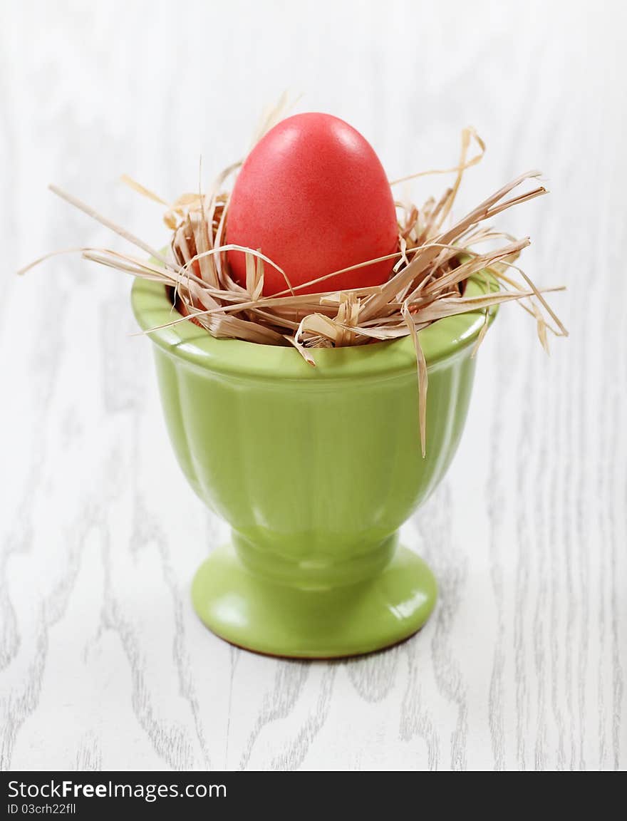 One egg in vase on wooden background