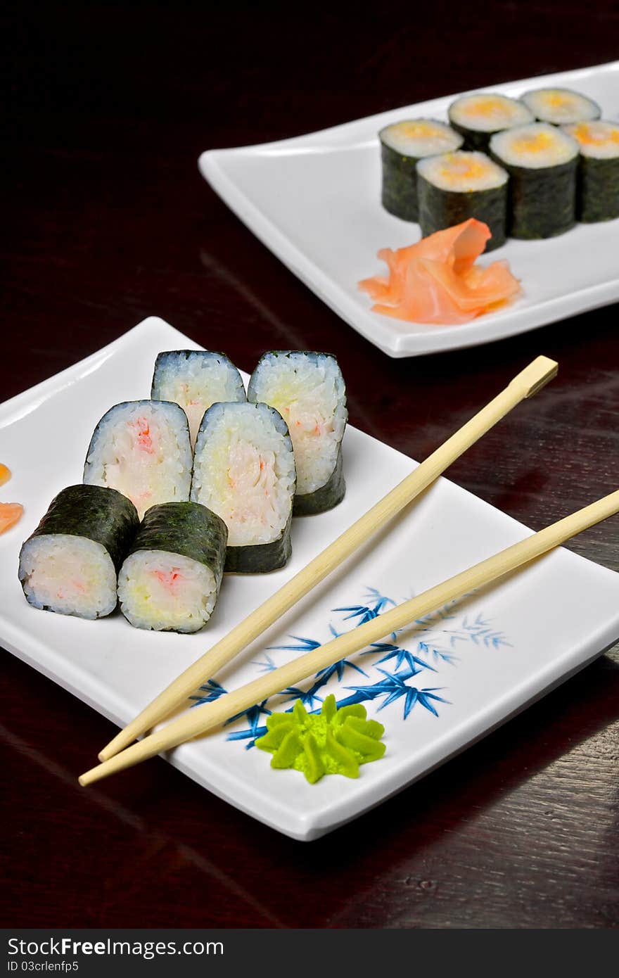 Sushi - Roll made of Smoked Eel, Cream Cheese and Deep Fried Vegetables inside. Fresh Salmon outside. Sushi on the plate