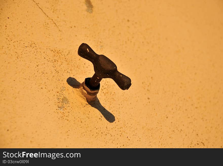 Rusty water tap on the wall