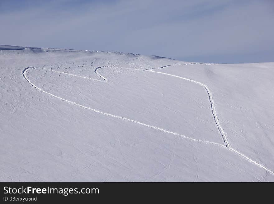 Heart shaped trails in a snow slope