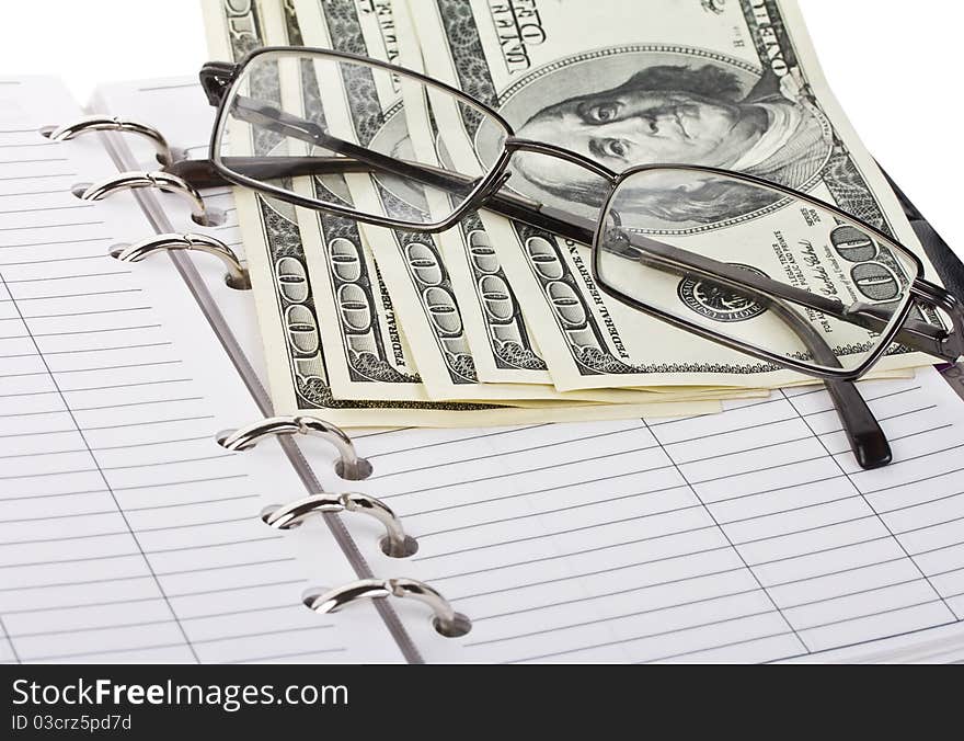 Opened notebook, dollars and glasses