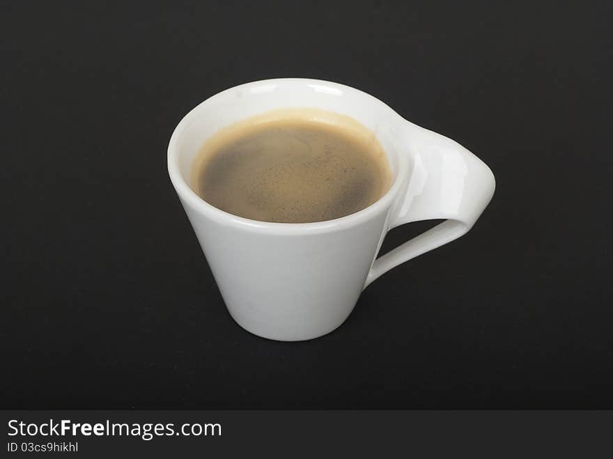 White cup of coffee without plate on black background