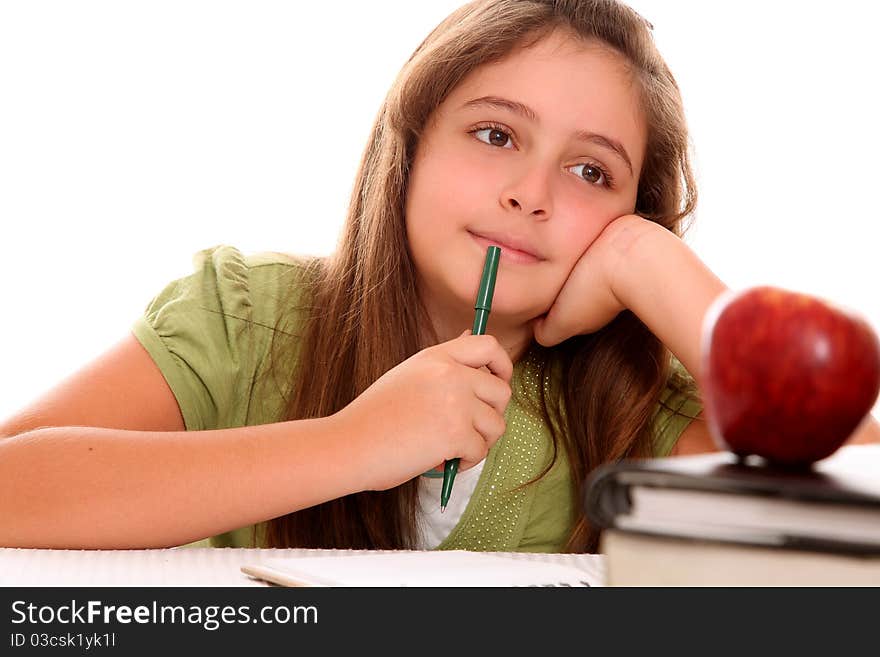 Studious girl thinking with his books and an apple on your desktop