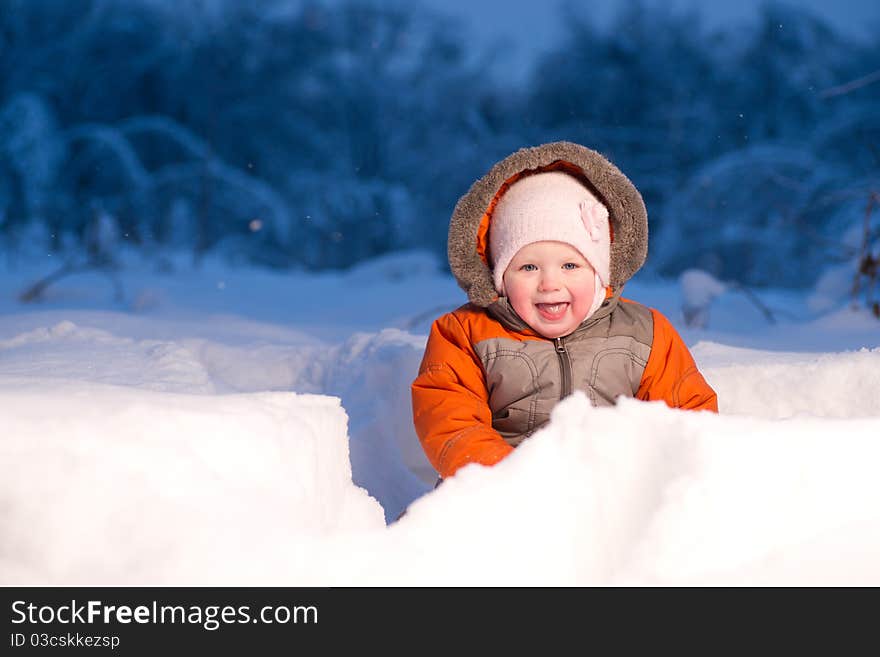 Adorable baby sit and digging hideout in snow