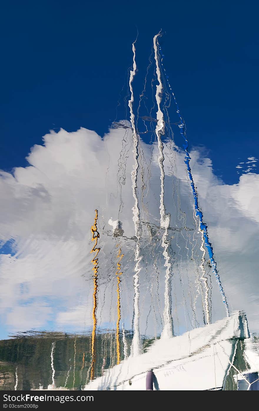 Sailboat reflection in the sea with blue sky and clouds