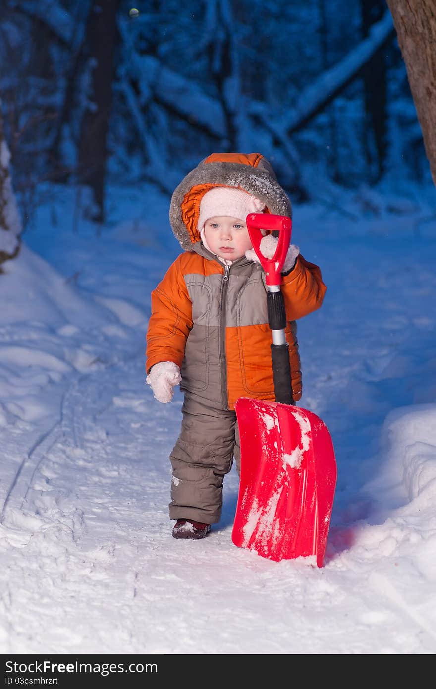 Adorable baby holding snow shovel