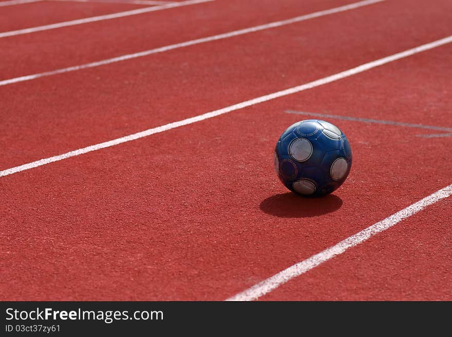 Dark blue soccer ball on run race track