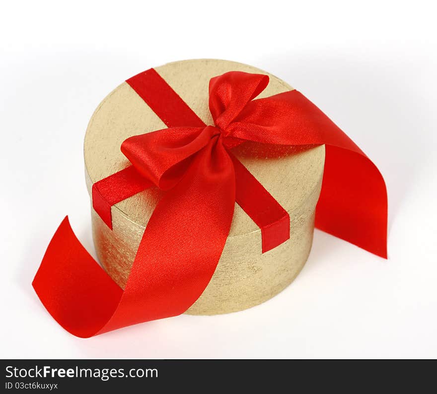 Golden box decorated with the red ribbon. Golden box decorated with the red ribbon