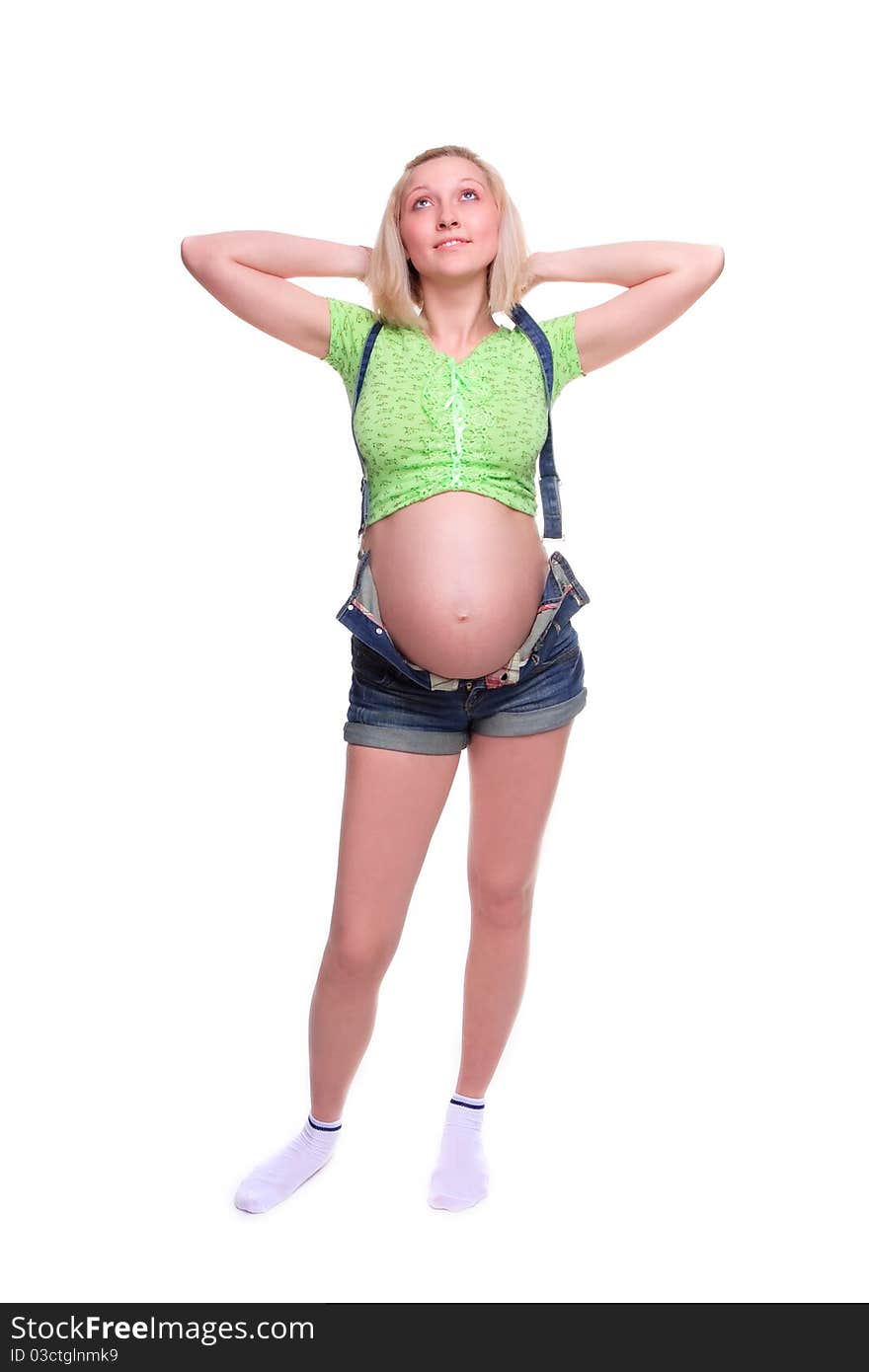 Young pretty pregnant woman posing in jeans overalls