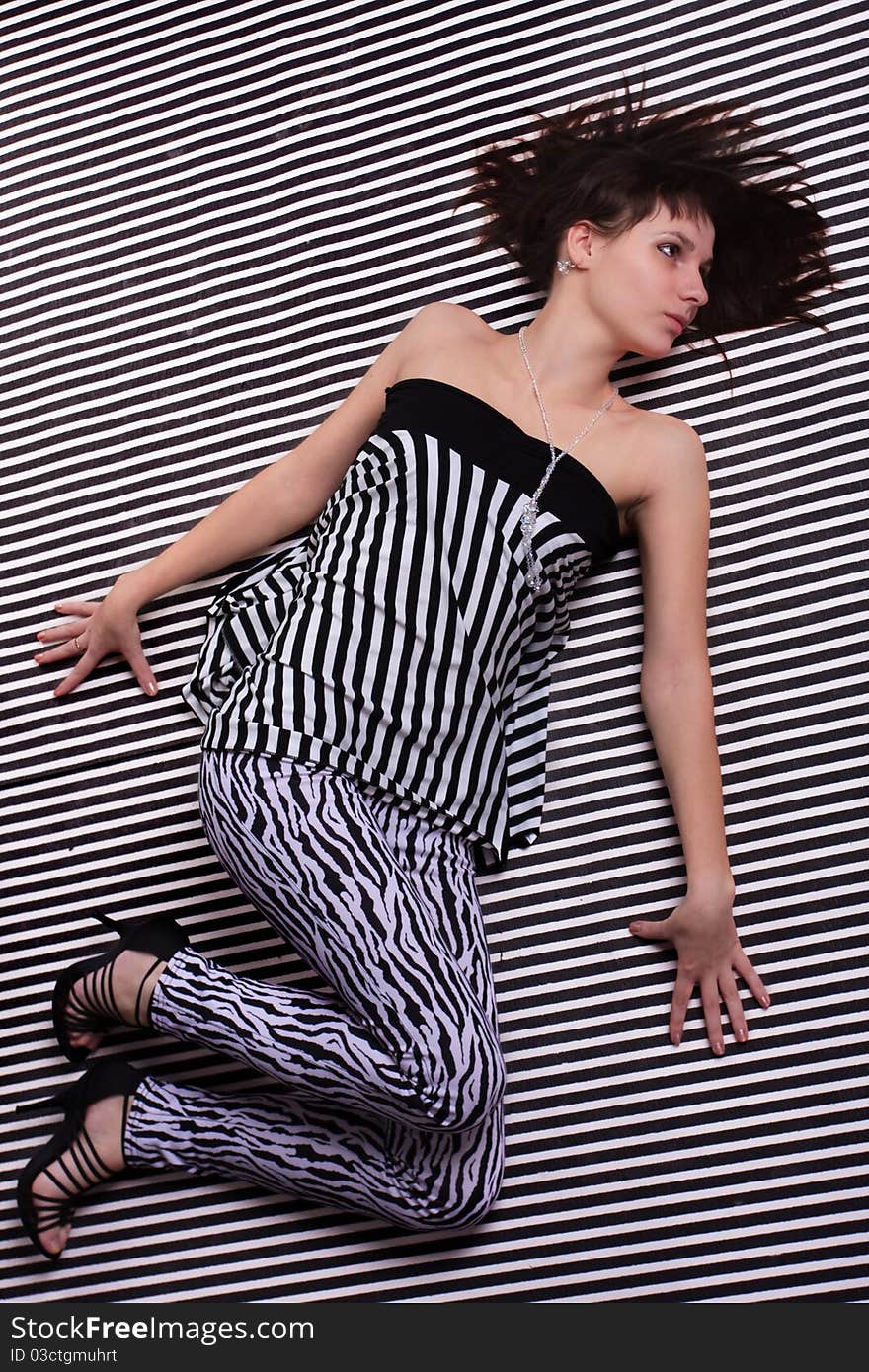 Cute girl in a striped clothes on the striped background