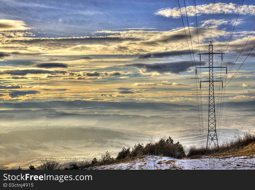 HDR image of hills in Romanian, beautifully bathed by a late winter sunset with a large electrical pole in foreground. HDR image of hills in Romanian, beautifully bathed by a late winter sunset with a large electrical pole in foreground.