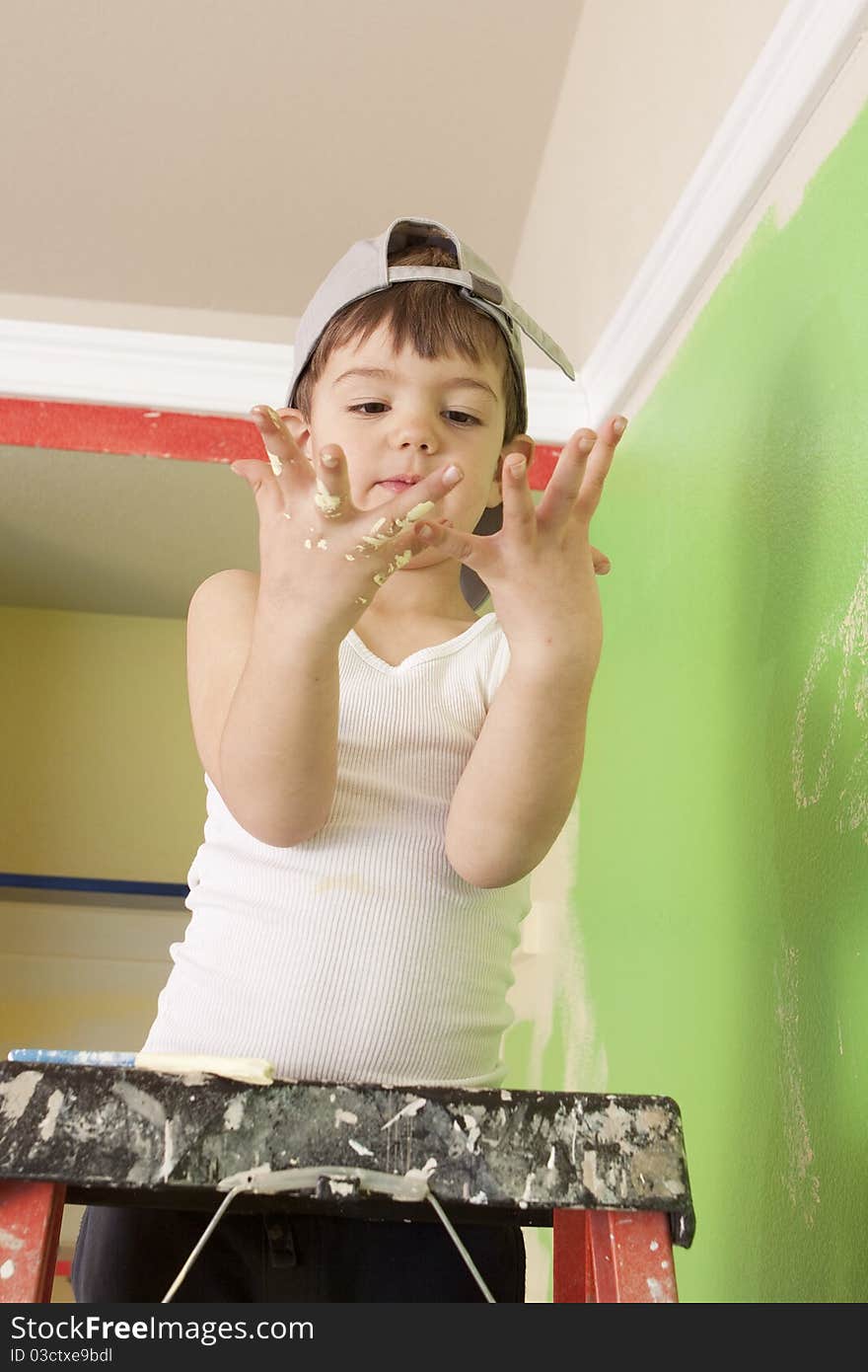 Young boy on a ladder with paint on his hands. Young boy on a ladder with paint on his hands.