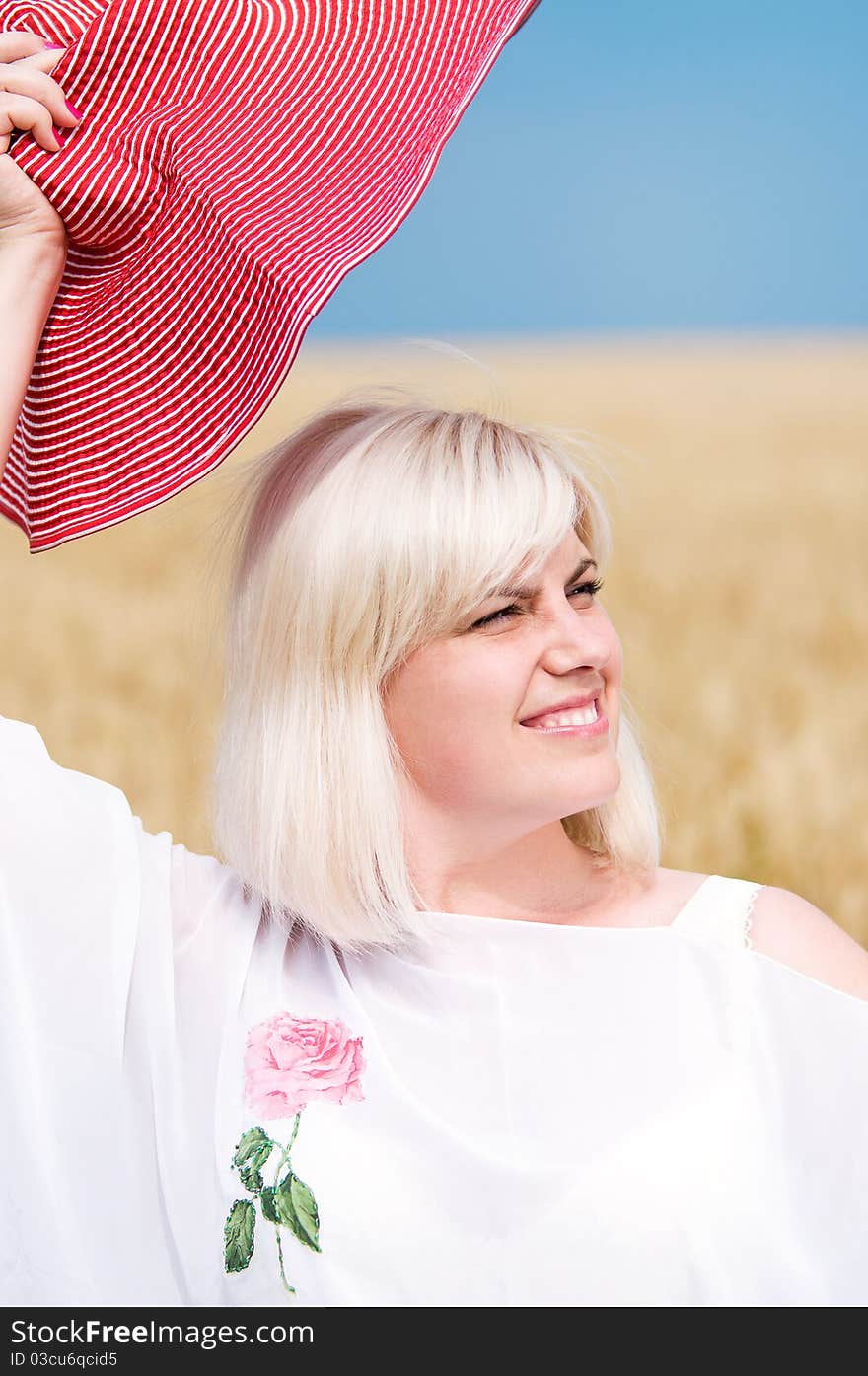 Beautiful woman with hat in wheat meadow on sunny day