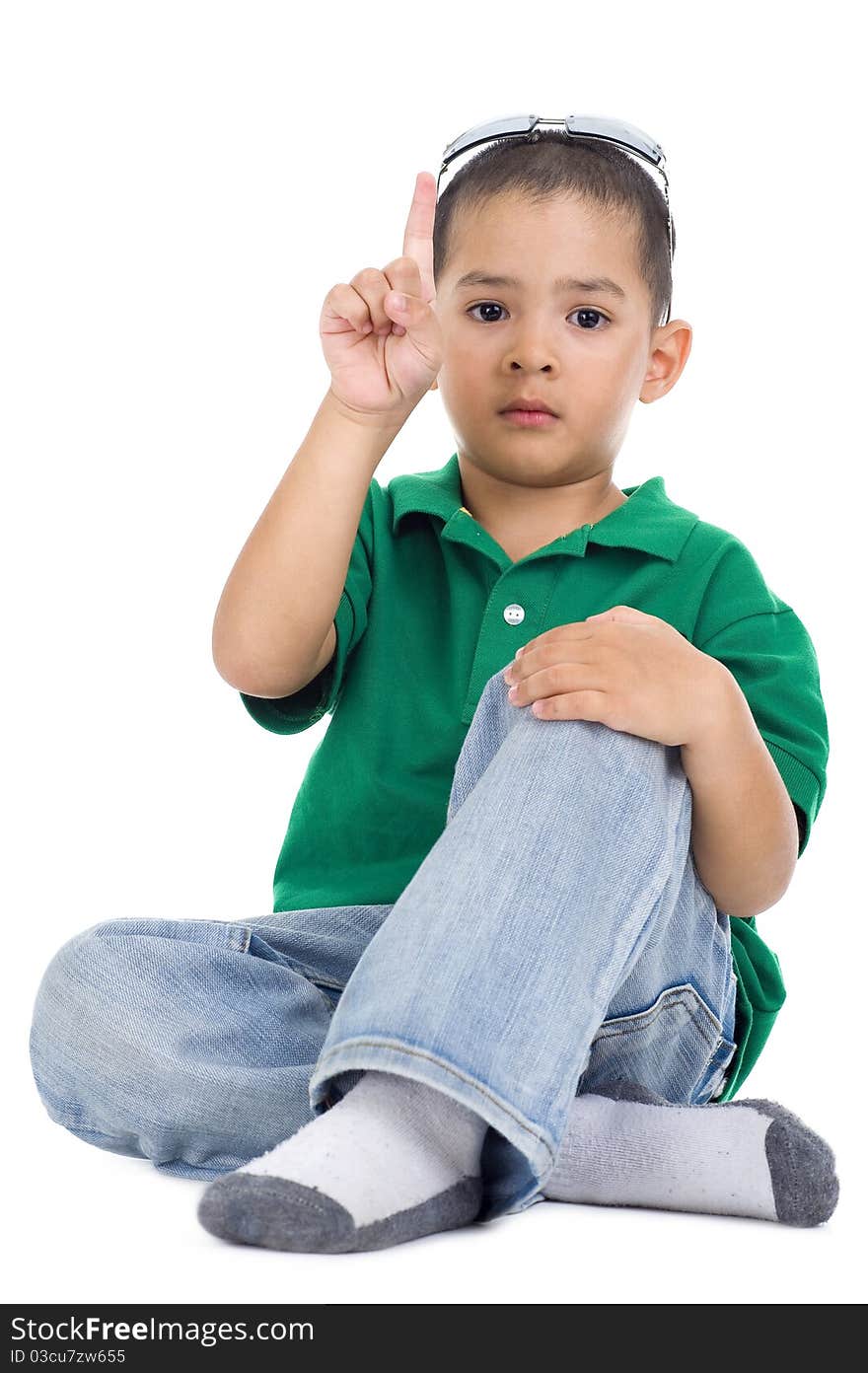 Boy with one finger raised, isolated on white background