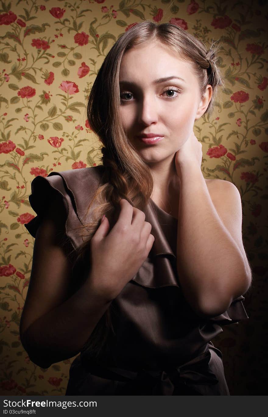 Portrait of the beauty young blond girl near the wall with roses