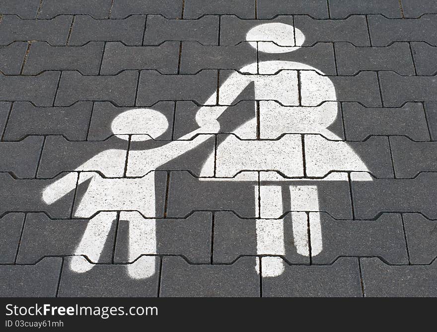 Mother with child parking lot. White sign painted on the pavement.