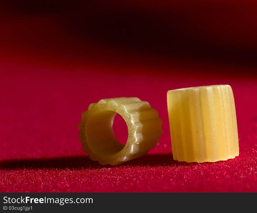 Italian pasta ditalini rigati on red background