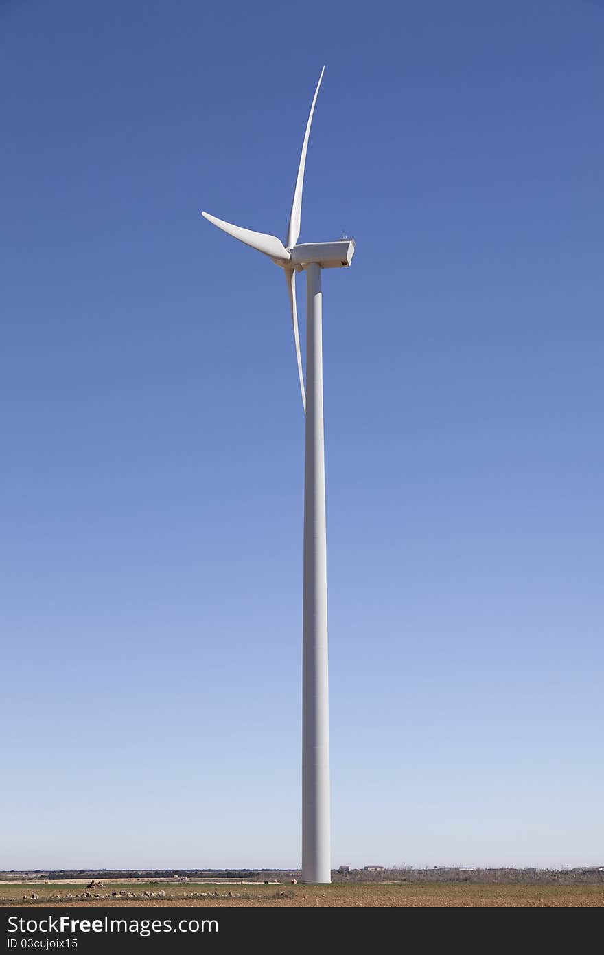 Lone windmill in the field, cut against the blue sky. Lone windmill in the field, cut against the blue sky