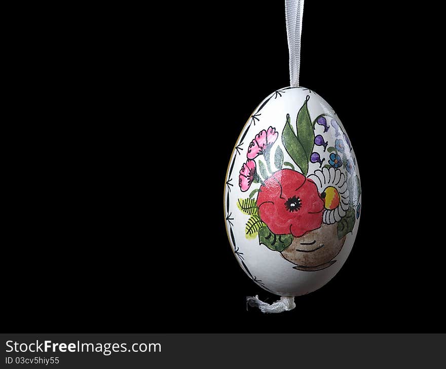 The image shows a hand painted easter egg over black