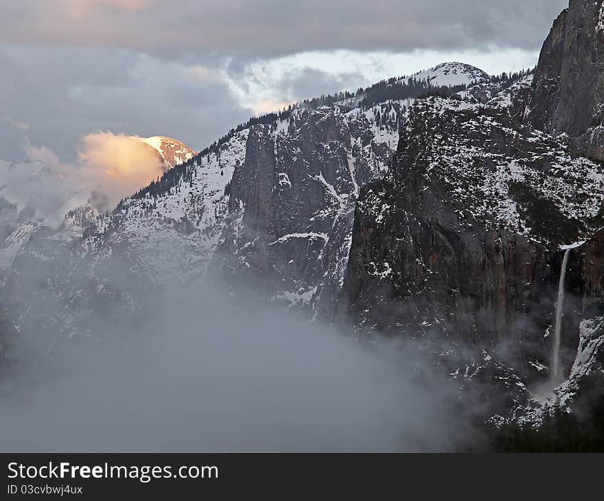 Last sun rays illuminating half dome at yosemite valley on a foogy late afternoon,giving the impression it is on fire,during a snow storm in late winter. Last sun rays illuminating half dome at yosemite valley on a foogy late afternoon,giving the impression it is on fire,during a snow storm in late winter.