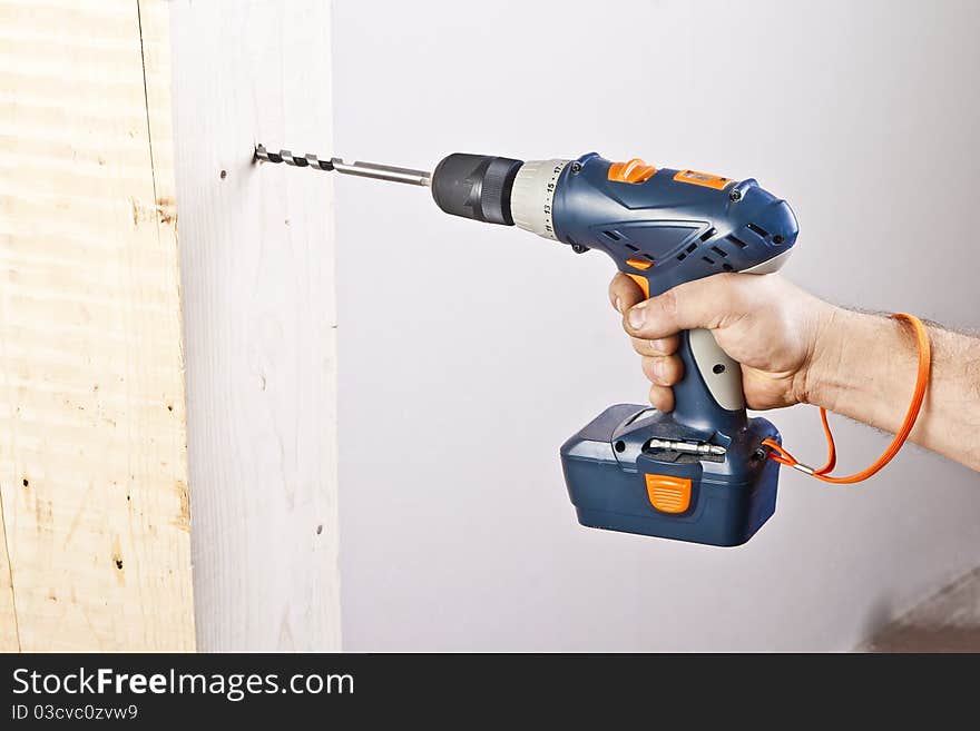 A man drilling a hole in wooden block. A man drilling a hole in wooden block