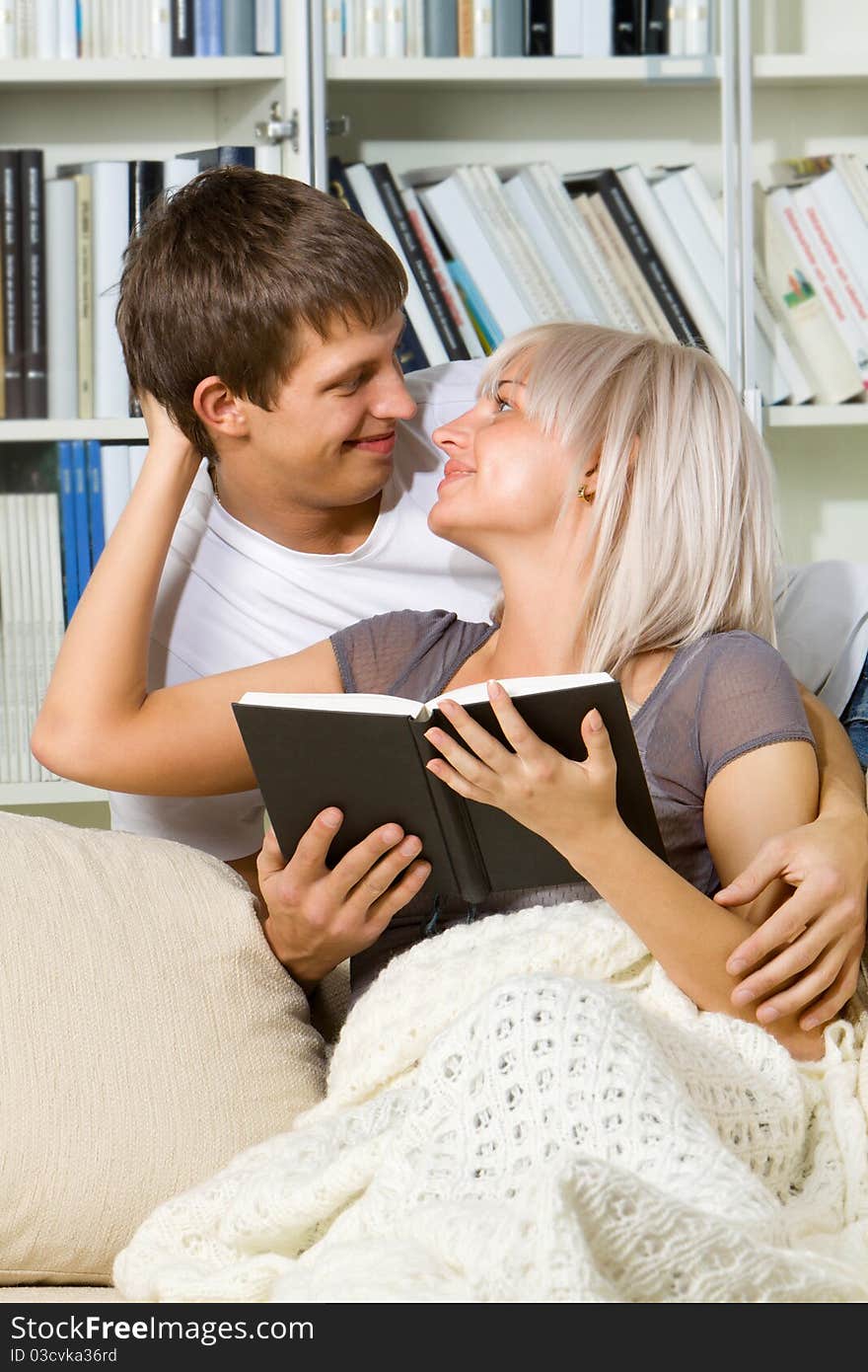 Young couple reading together at home