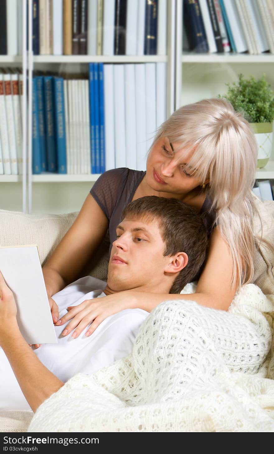 Young couple reading in their bedroom. Young couple reading in their bedroom