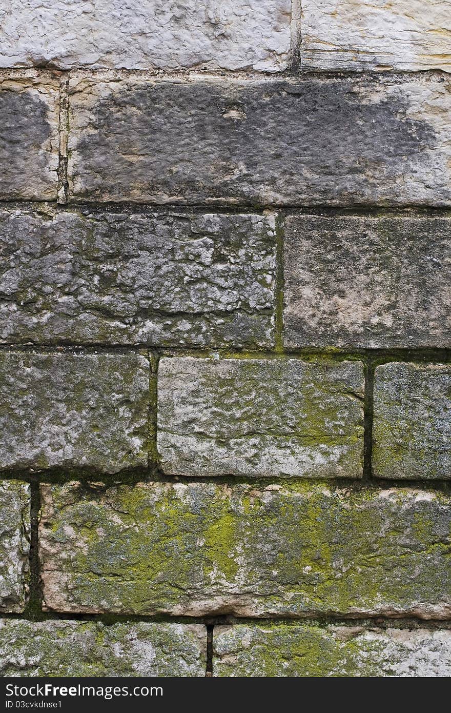 Old brick wall with moss and soot