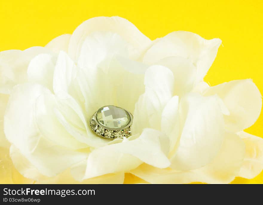 Closeup of fabric flower over yellow background