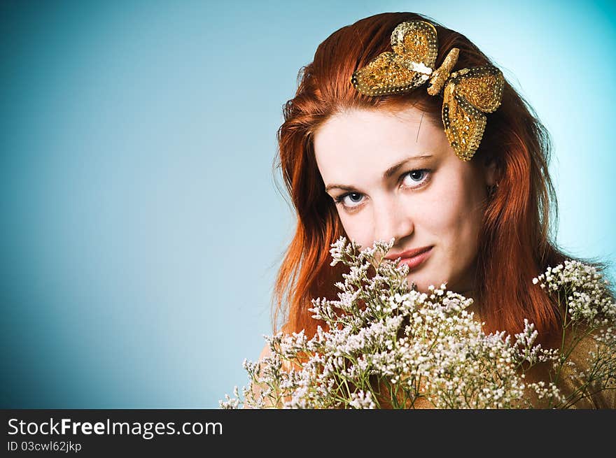 Beautiful girl with a golden butterfly in her hair