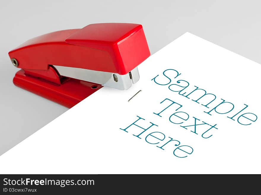 red stapler lies on a white background