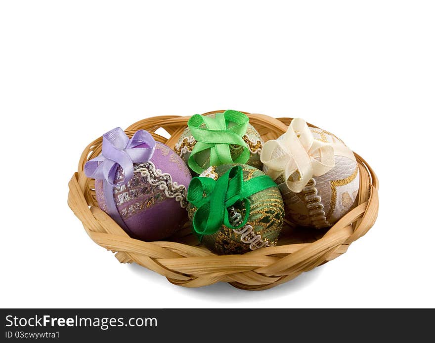 Four Easter eggs in a basket isolated on white