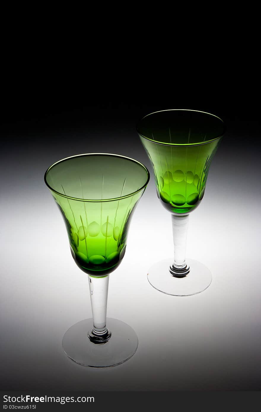 An image of two green glasses used for wine