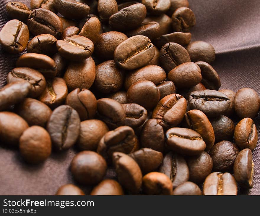 Roasted coffee beans on brown textile