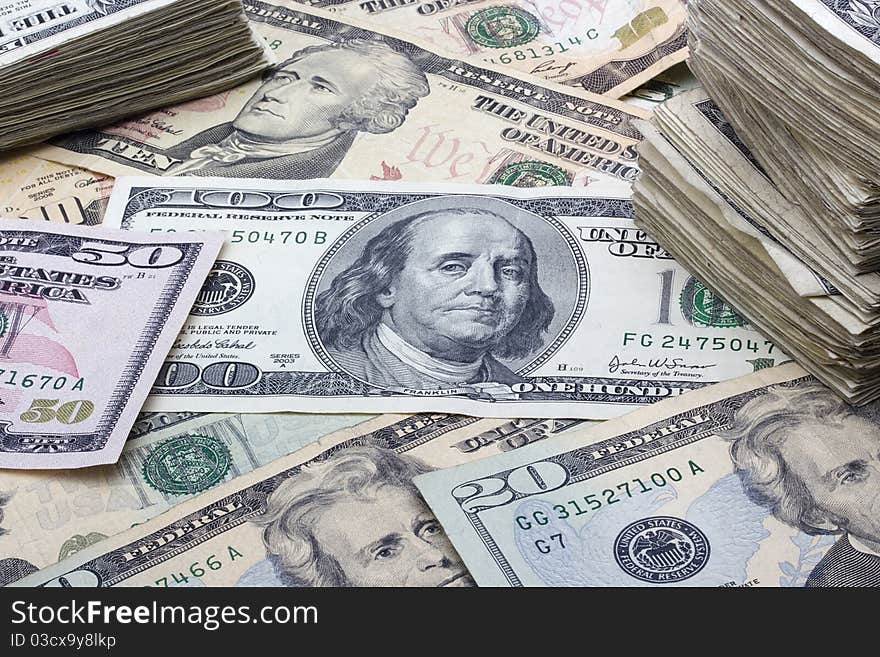 Variety of American money laid out under a stack of cash.