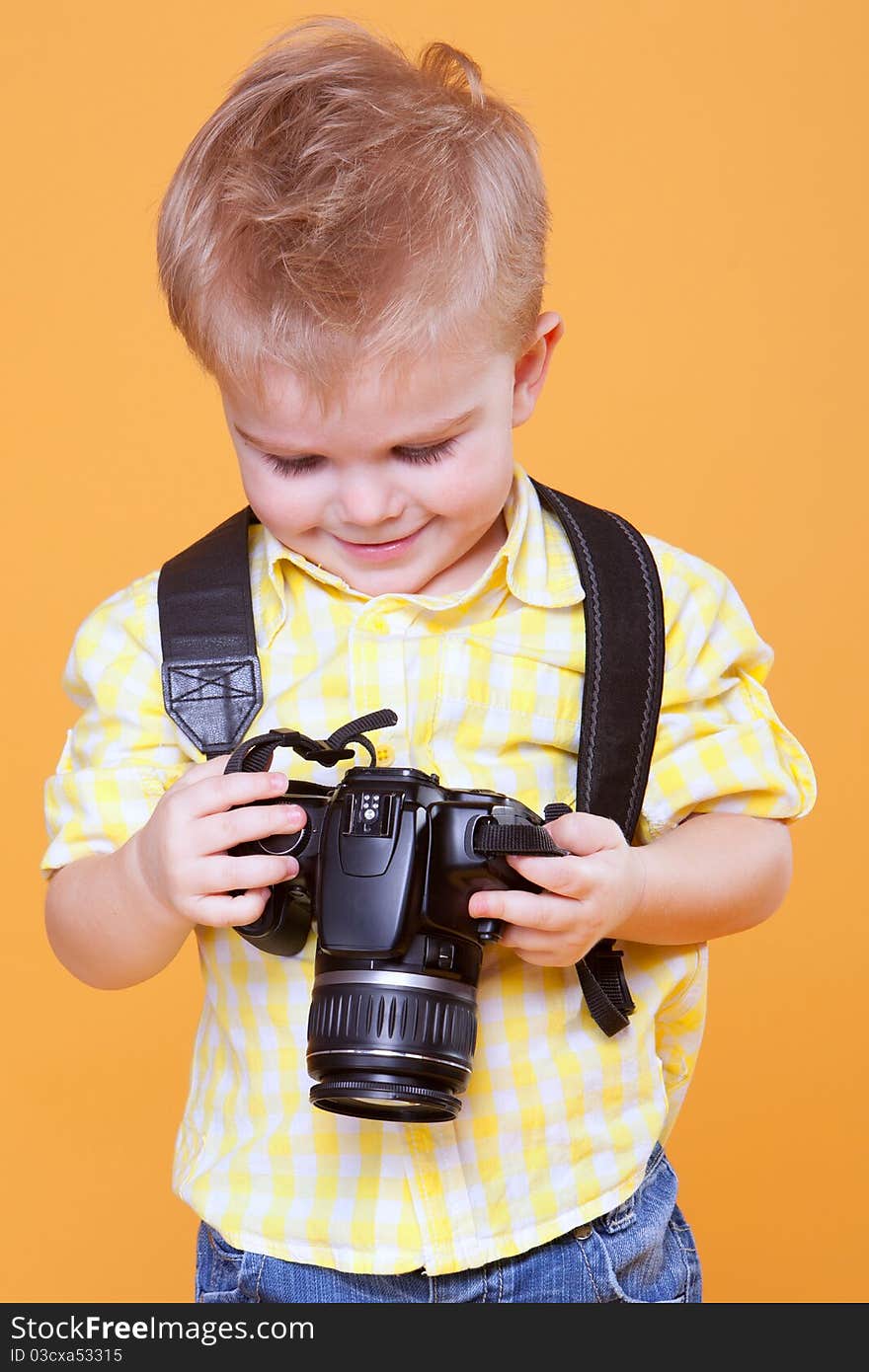 Little smiling photographer watching photo on professional camera. Little smiling photographer watching photo on professional camera