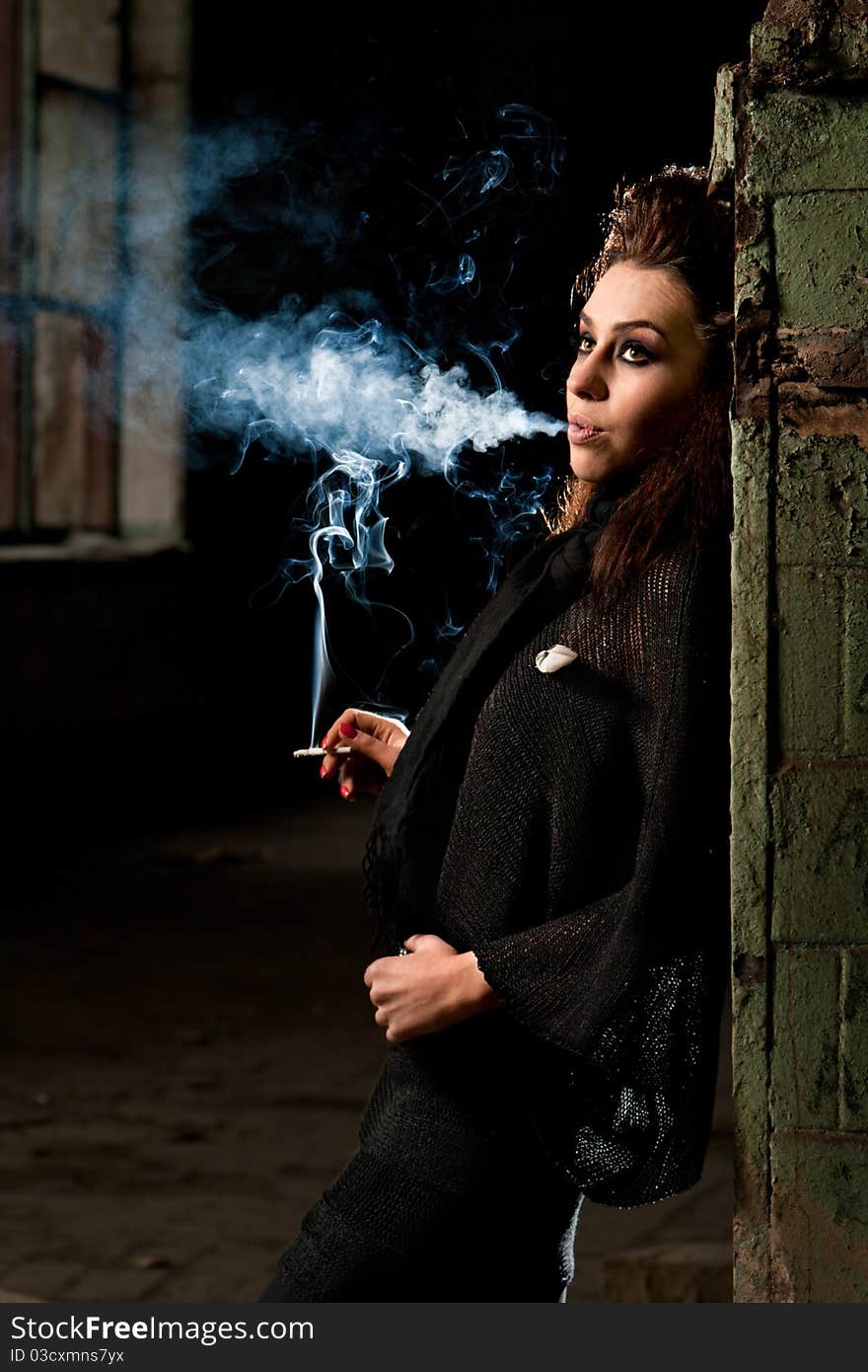 Woman smokes in the dark room